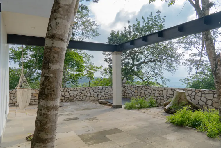 Terraza bajo una pérgola de acero, con hamaca y vista al valle