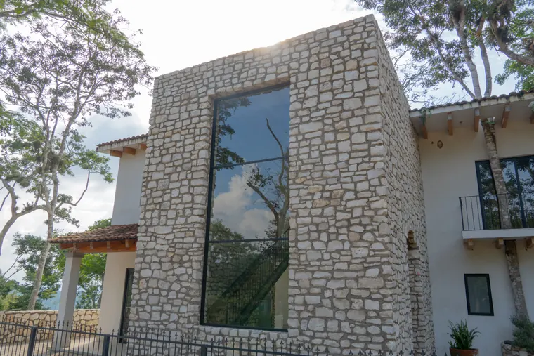 Volumen de piedra con ventanal que refleja el cielo
